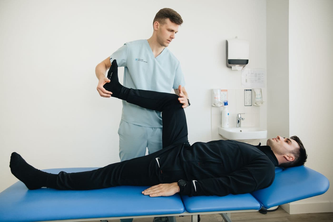 Physiotherapist guiding a patient through a leg exercise