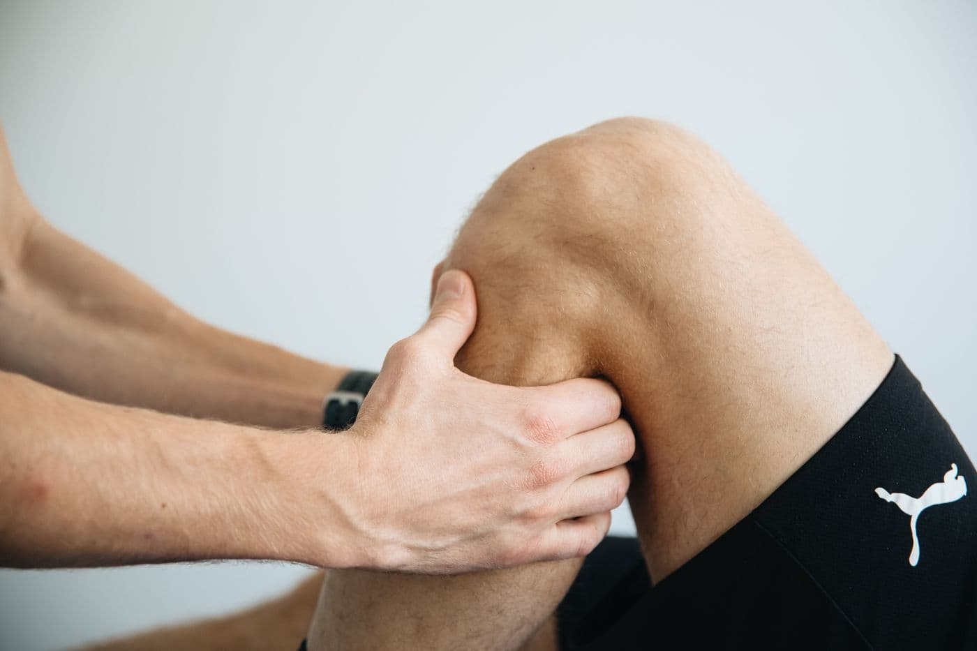 Hands supporting a knee during a calm physiotherapy session