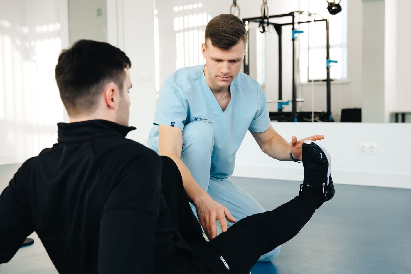 Physiotherapist examining a patient's leg in a clinic